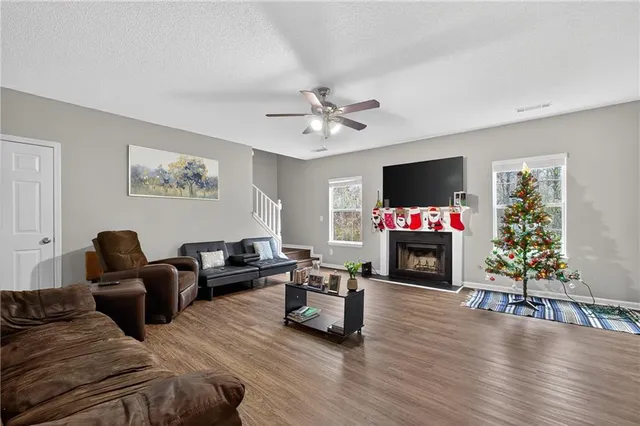 a living room with furniture a flat screen tv and a fireplace