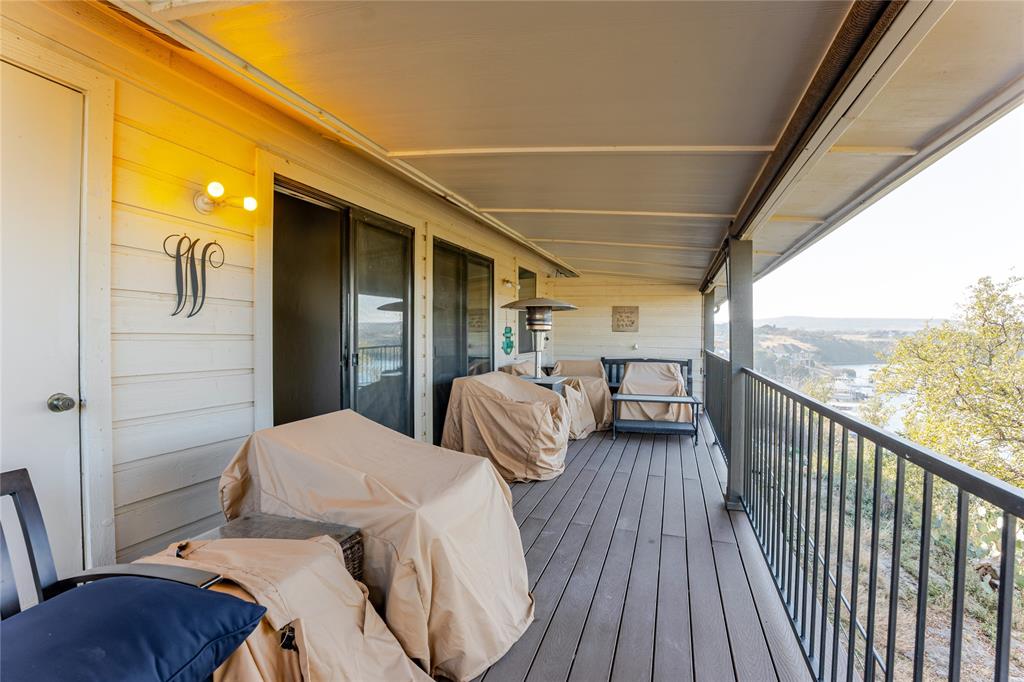 3037 Hells Gate Loop, Unit C208 Strawn, TX 76475 - Photo 4 of 23 a balcony with wooden floor table and chairs