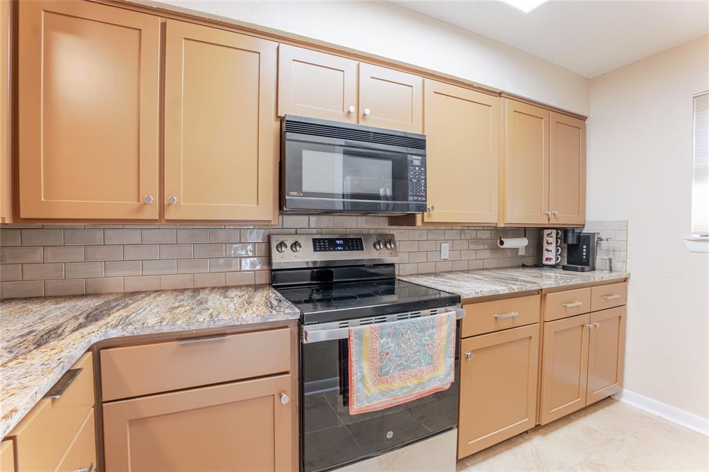 3037 Hells Gate Loop, Unit C208 Strawn, TX 76475 - Photo 7 of 23 a kitchen with granite countertop cabinets stainless steel appliances and a sink