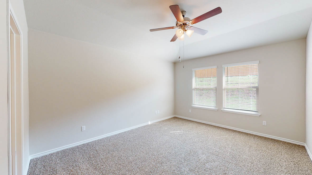 429 Creekfall Road Burnet, TX 78611 - Photo 16 of 28 A quiet bedroom offering comfort and a functional ceiling fan with lighting.