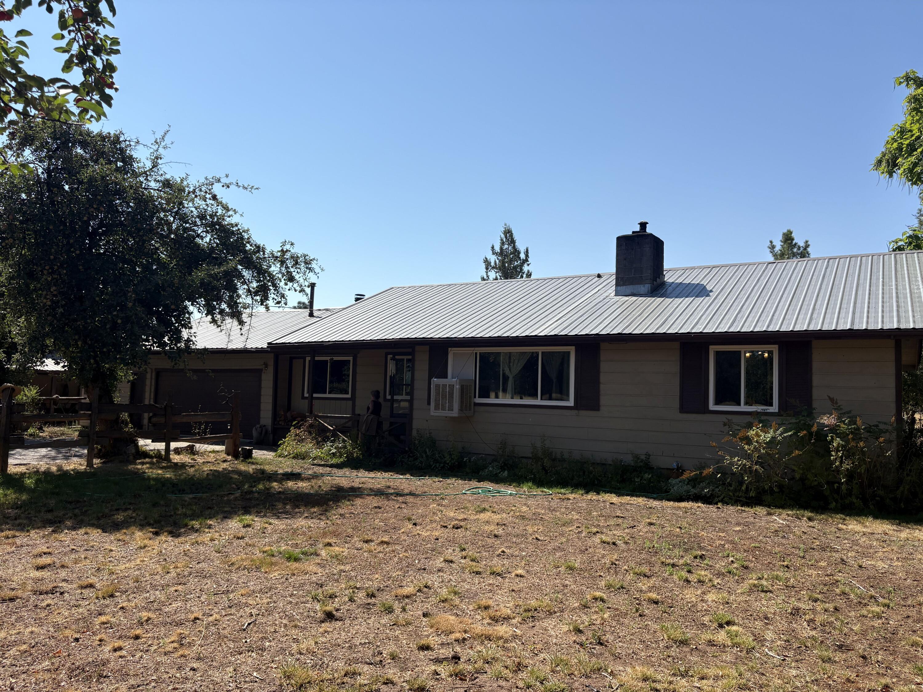 a front view of house with yard and trees in the background