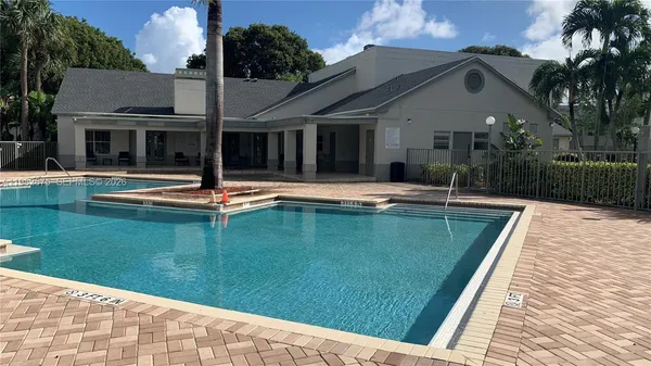 a house view with swimming pool in front of it