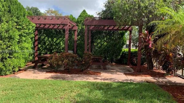 a view of a house with a yard and a bench