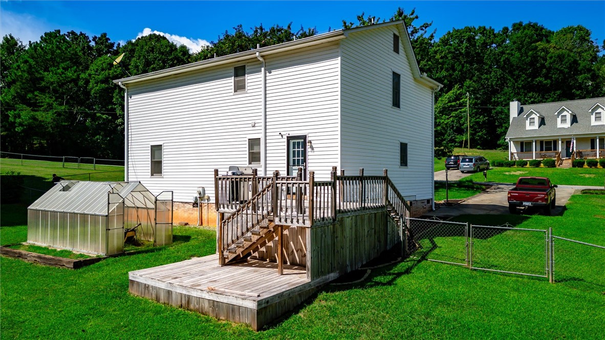 519 Hillandale Road Liberty, SC 29657 - Photo 23 of 24 A spacious wooden deck overlooks the grassy backyard featuring a small greenhouse structure.