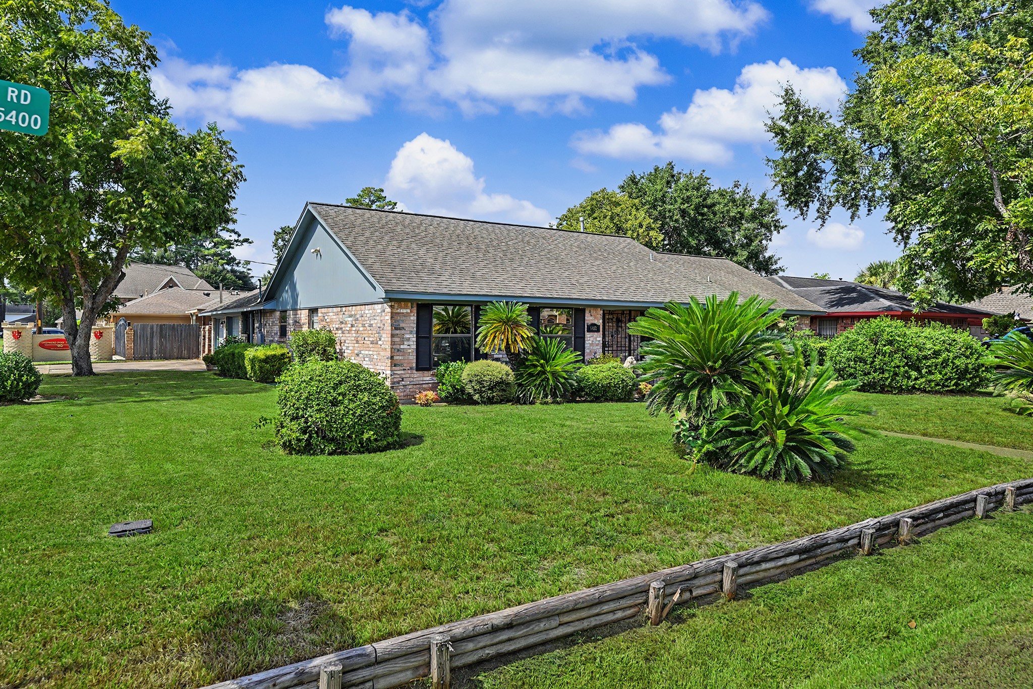 5403 Boots Road Houston, TX 77091 - Photo 2 of 26 Expansive and beautifully landscaped, this large corner yard offers a perfect blend of lush greenery and inviting charm.