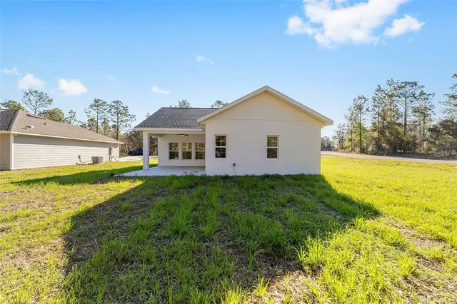 a view of a house with a big yard and potted plants