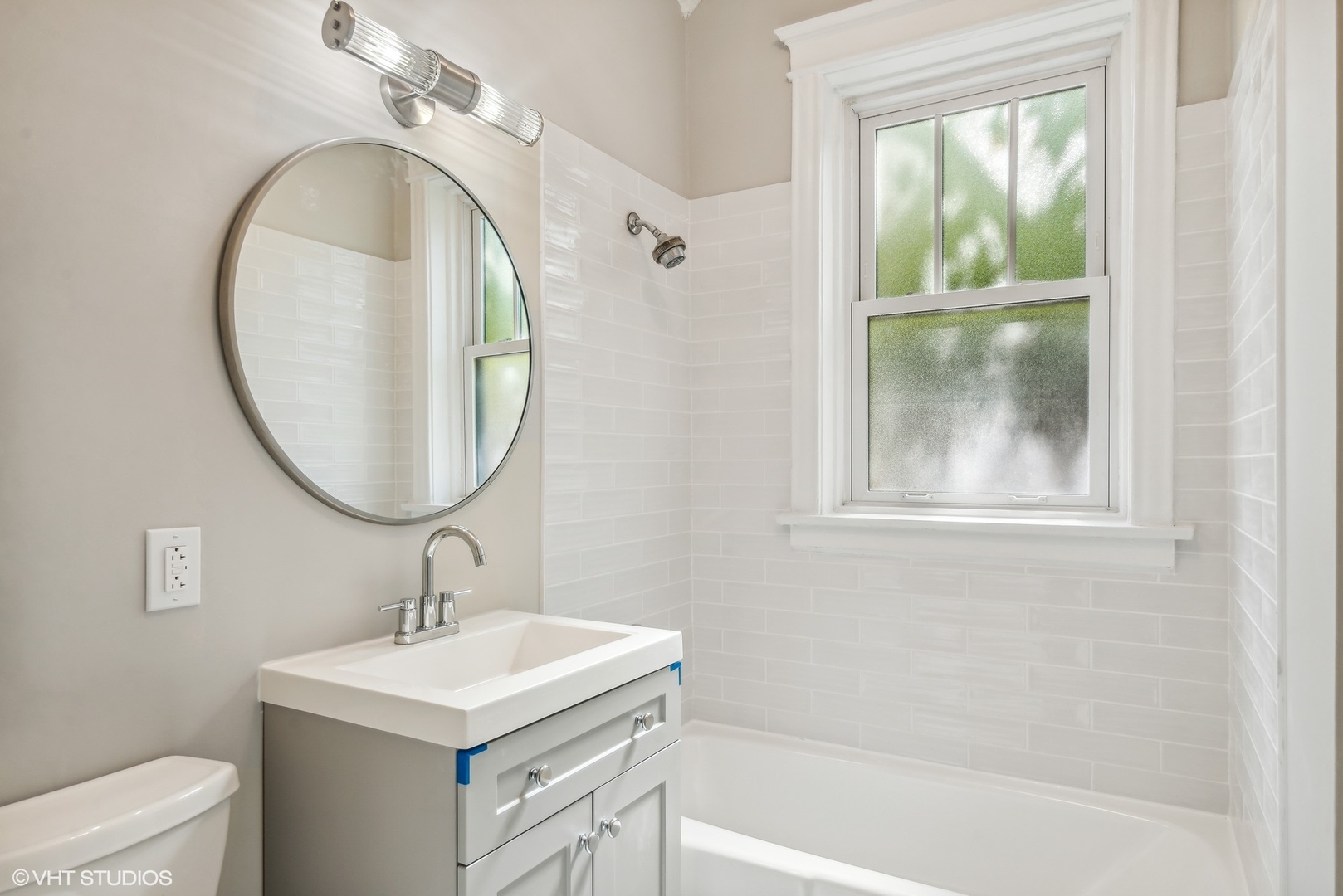 501 West Belmont Avenue, Unit 1 Chicago, IL 60657 - Photo 6 of 17 a bathroom with a sink a mirror and a bathtub