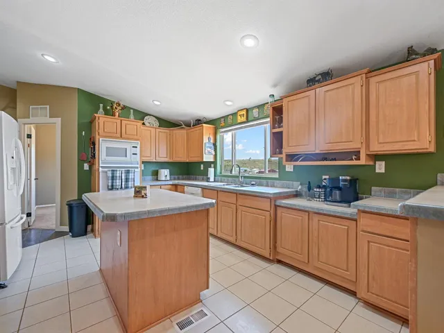 a kitchen with granite countertop appliances sink and cabinets