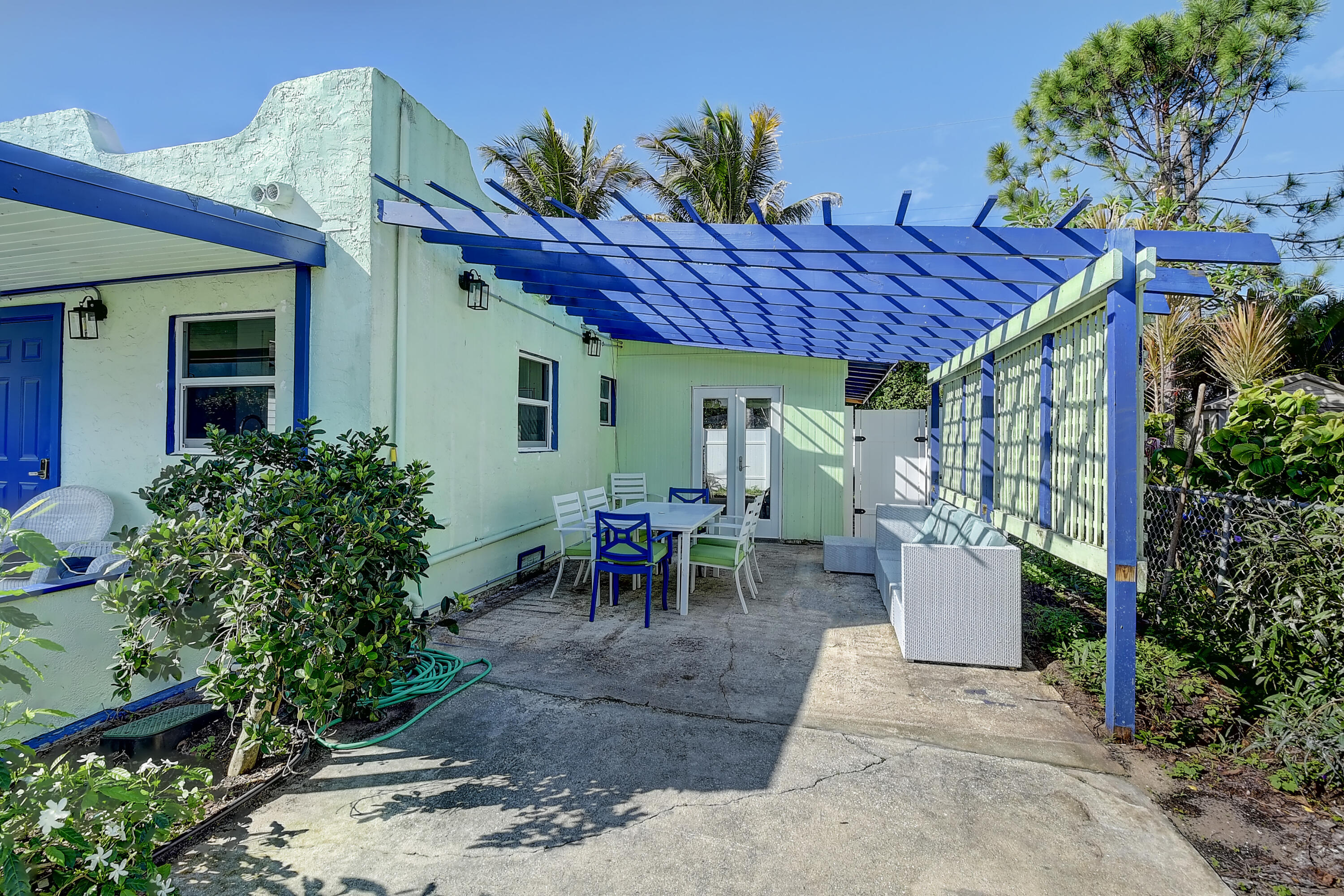 212 Southwest 1st Avenue Delray Beach, FL 33444 - Photo 4 of 15 a view of a patio with table and chairs potted plants and a large tree