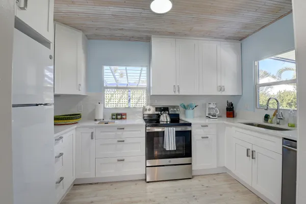 a kitchen with cabinets appliances and a window