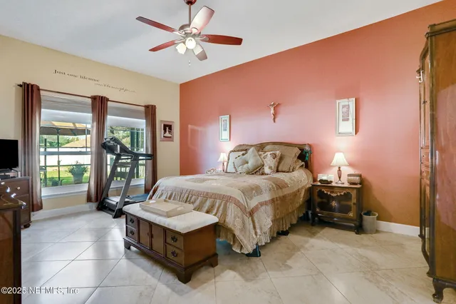 a bedroom with a bed a dresser and a large window