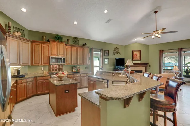 a large kitchen with kitchen island granite countertop a sink counter space appliances and cabinets