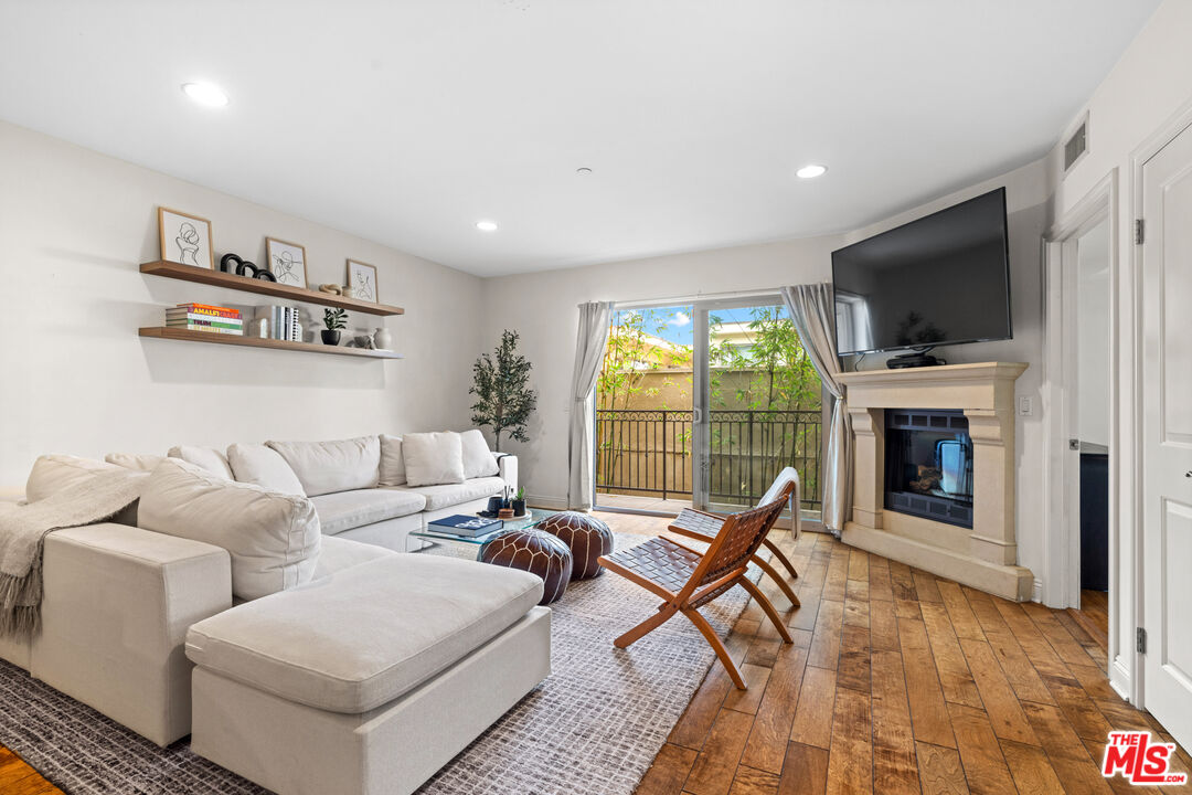 8238 West Manchester Avenue, Unit 204 Playa del Rey, CA 90293 - Photo 4 of 23 a living room with furniture a flat screen tv and a fireplace