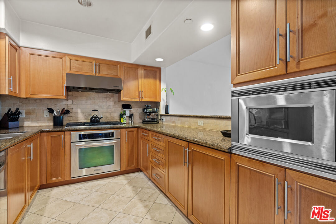8238 West Manchester Avenue, Unit 204 Playa del Rey, CA 90293 - Photo 8 of 23 a kitchen with stainless steel appliances granite countertop a sink and a stove