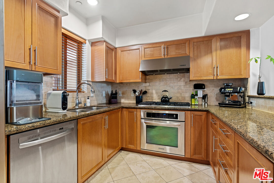 8238 West Manchester Avenue, Unit 204 Playa del Rey, CA 90293 - Photo 9 of 23 a kitchen with stainless steel appliances granite countertop a stove sink and cabinets