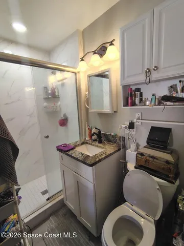 a bathroom with a granite countertop sink a mirror and shower