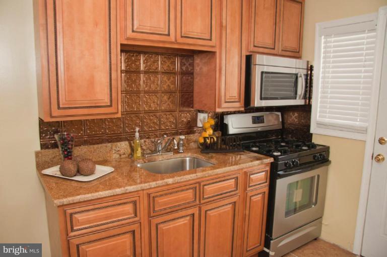 1949 Quentin Road Dundalk, MD 21222 - Photo 6 of 21 a kitchen with granite countertop a sink stove and cabinets