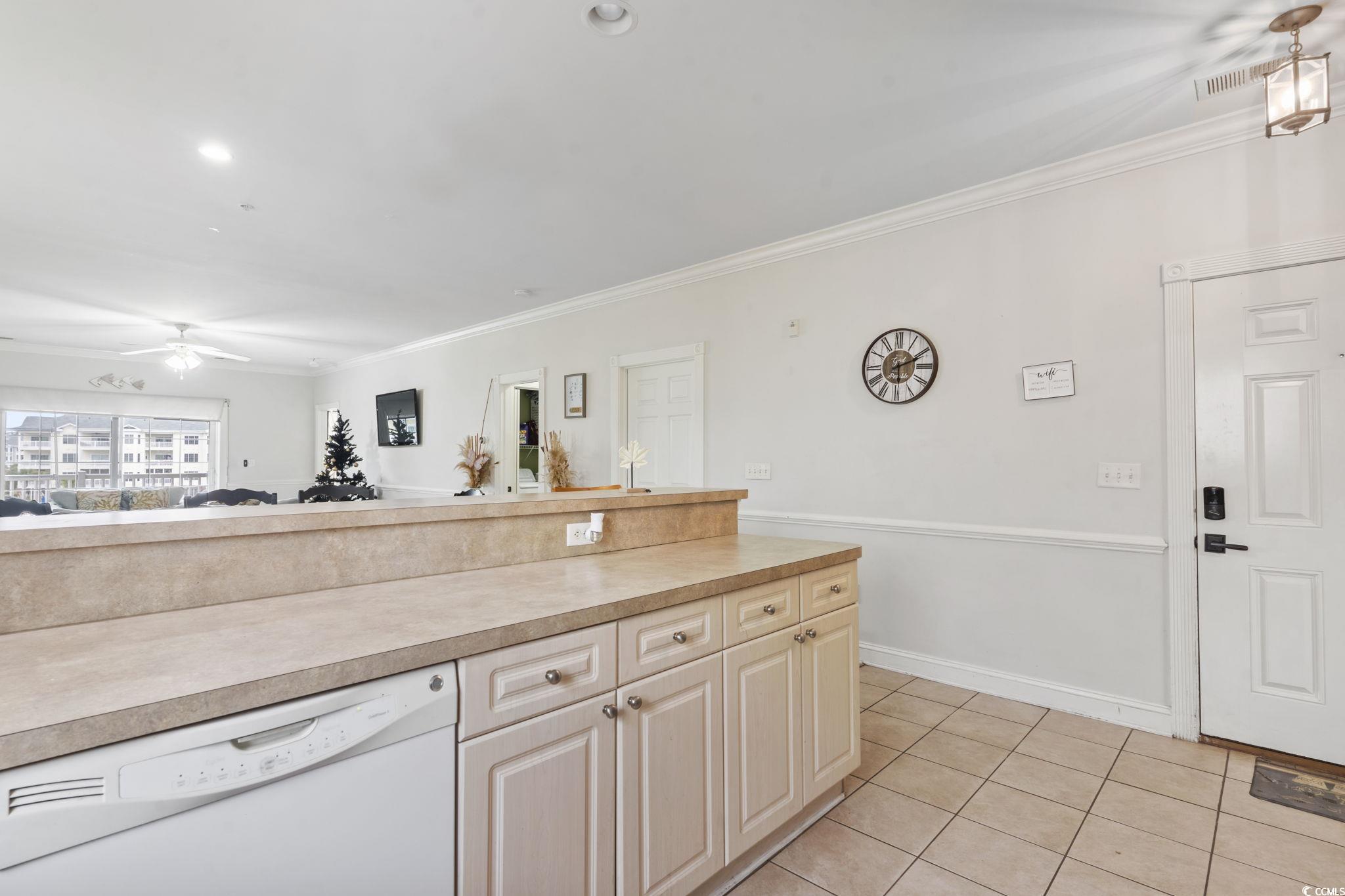 4847 Luster Leaf Circle, Unit 301 Myrtle Beach, SC 29577 - Photo 16 of 16 Kitchen featuring white dishwasher, light countertops, open floor plan, light tile patterned floors, and a ceiling fan