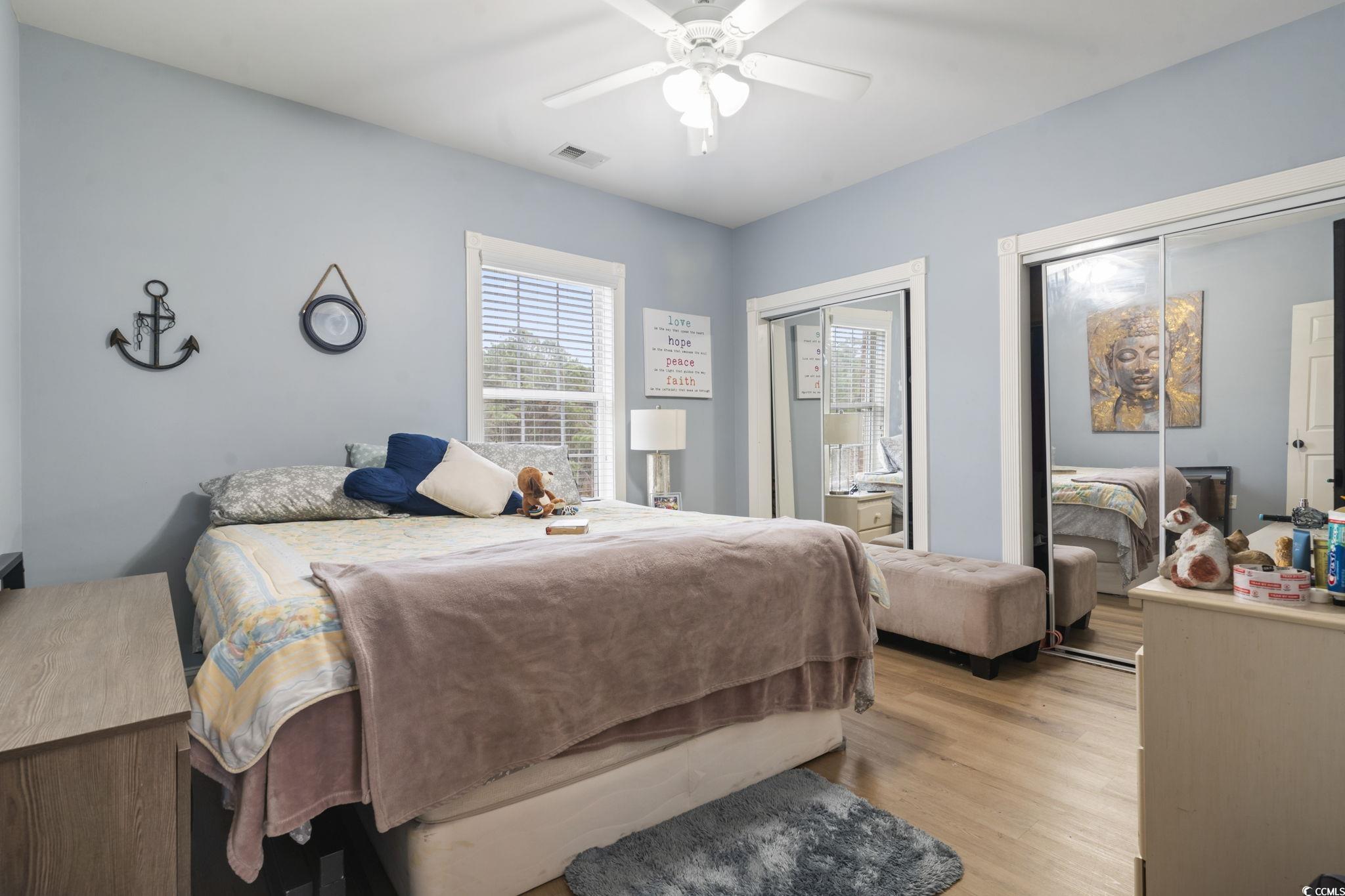4847 Luster Leaf Circle, Unit 301 Myrtle Beach, SC 29577 - Photo 8 of 16 Bedroom featuring multiple closets, wood finished floors, and ceiling fan