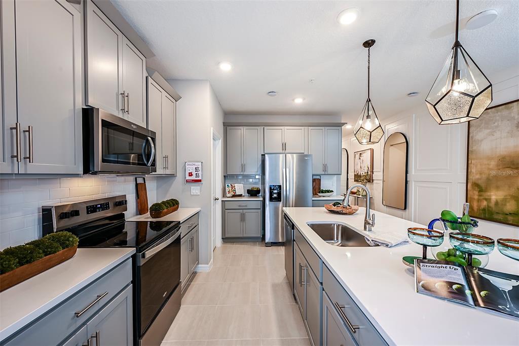 551 Southern Edge Way Sanford, FL 32771 - Photo 5 of 15 a kitchen with stainless steel appliances granite countertop a sink stove and refrigerator