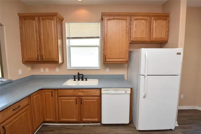 a kitchen with a refrigerator sink and cabinets