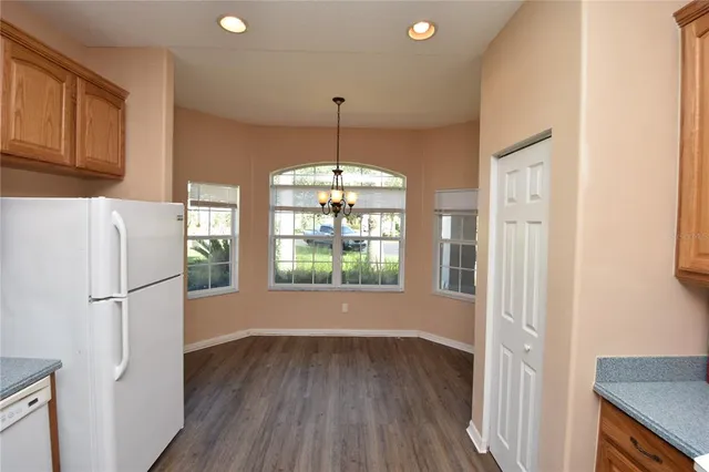 a kitchen with a refrigerator a stove top oven a sink and dishwasher with wooden floor