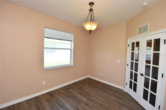 a view of a room with wooden floor and a window