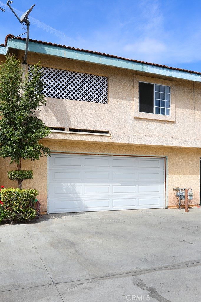 8032 Rose Street, Unit 13 Paramount, CA 90723 - Photo 24 of 25 a front view of a house with a garage