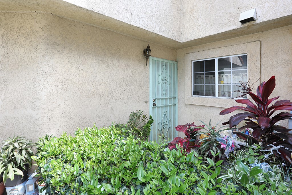 8032 Rose Street, Unit 13 Paramount, CA 90723 - Photo 4 of 25 view of a backyard with potted plants and brick walls