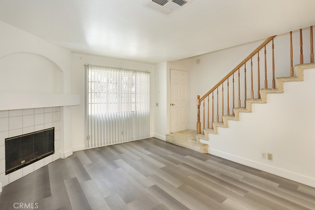 8032 Rose Street, Unit 13 Paramount, CA 90723 - Photo 7 of 25 a view of an empty room with wooden floor and a window