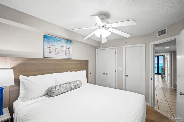 a bedroom with a large bed and a chandelier