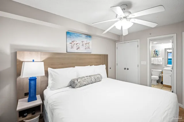 a bedroom with a large bed and a chandelier