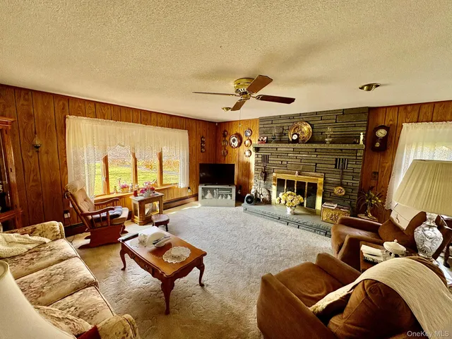 a living room with furniture a fireplace and a large window