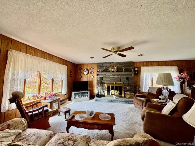 a living room with fireplace furniture and a large window