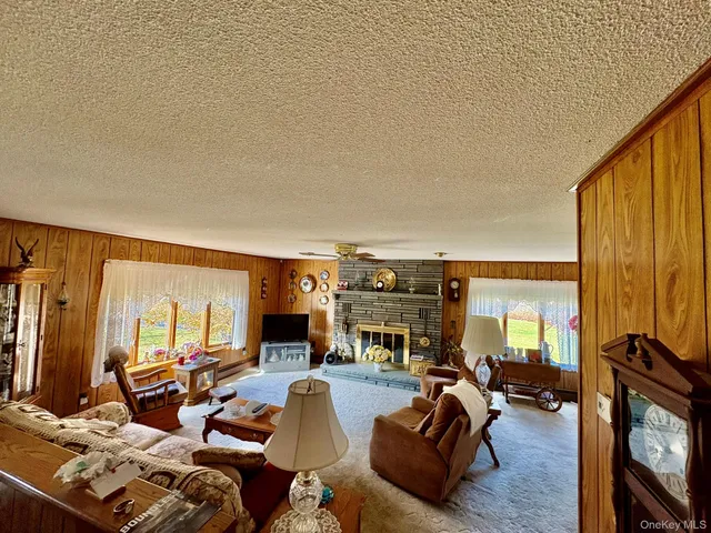 a living room with furniture a fireplace and large windows