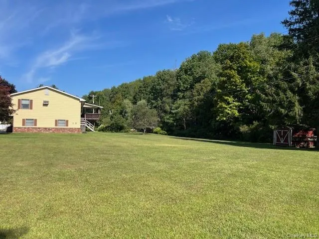 a view of a field with an trees in the background