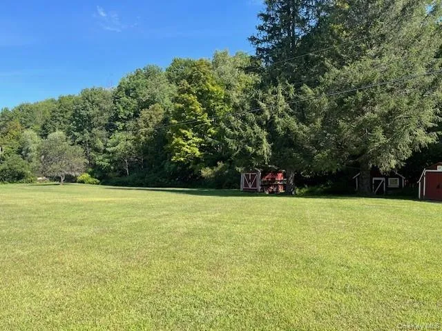 a view of a field with trees in the background