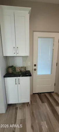 a view of kitchen with granite countertop white cabinets with a sink