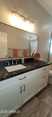 a bathroom with a granite countertop sink and a mirror