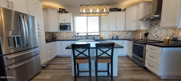 a kitchen with stainless steel appliances a sink stove and cabinets