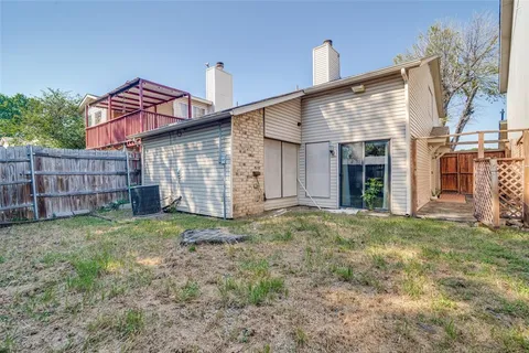 a view of a house with a yard and wooden fence