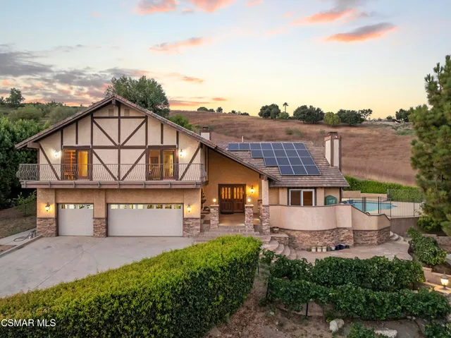 a view of a big house with a big yard and large tree