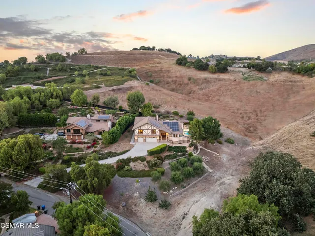 an aerial view of green landscape with trees houses and mountain view