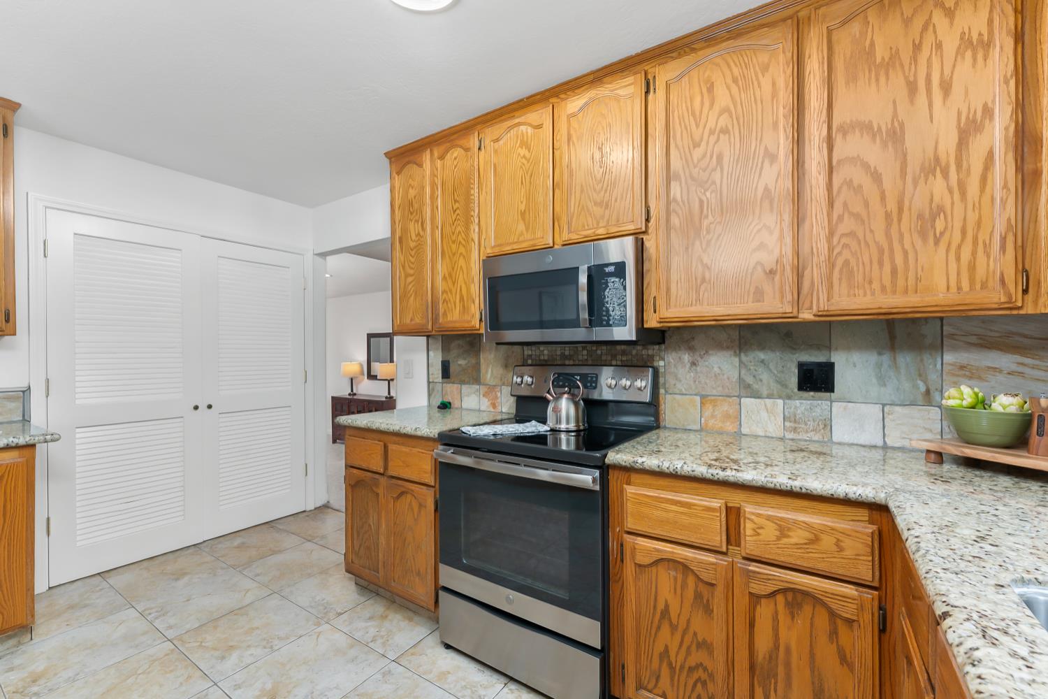 2960 Pasada Road Cameron Park, CA 95682 - Photo 12 of 40 a kitchen with stainless steel appliances granite countertop a stove a sink and a microwave