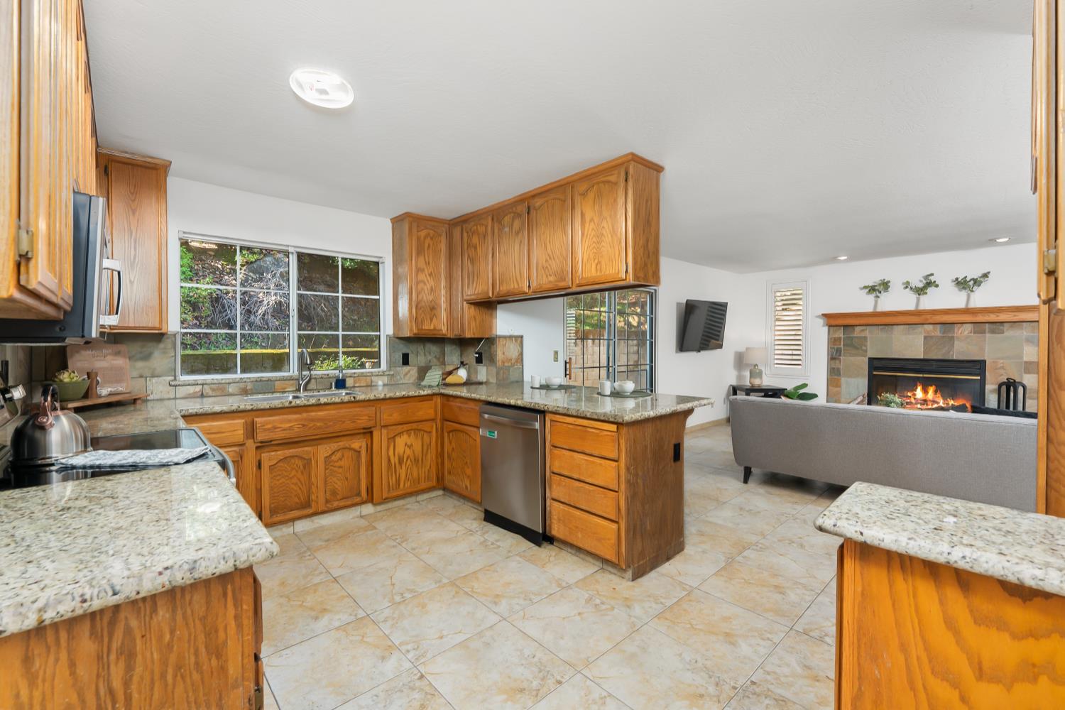 2960 Pasada Road Cameron Park, CA 95682 - Photo 10 of 40 a kitchen with stainless steel appliances granite countertop wooden cabinets a stove top oven a sink and dishwasher