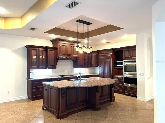 a kitchen with a sink a chandelier and living area view