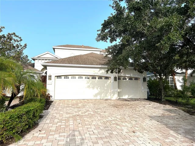 a view of a house with a yard and a large tree