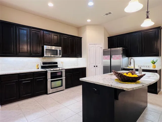 a kitchen with a sink a stove and wooden cabinets
