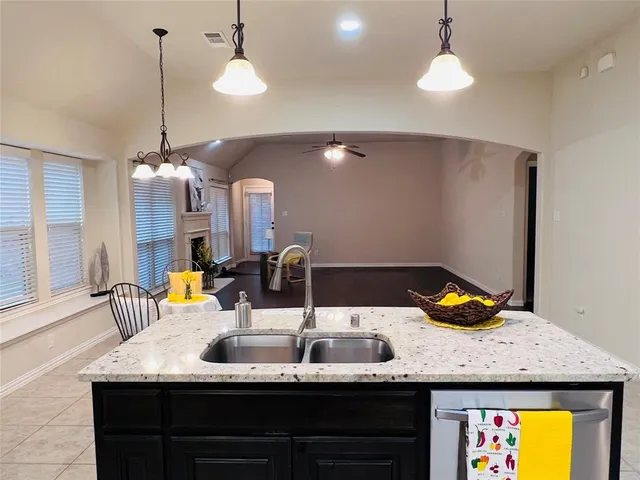 a kitchen with a sink a chandelier and living room view