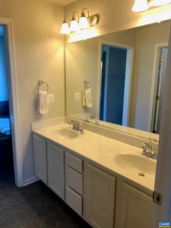 a bathroom with a double vanity sink and a mirror
